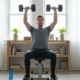 Man performing a chest press exercise with dumbbells on a weight bench at home